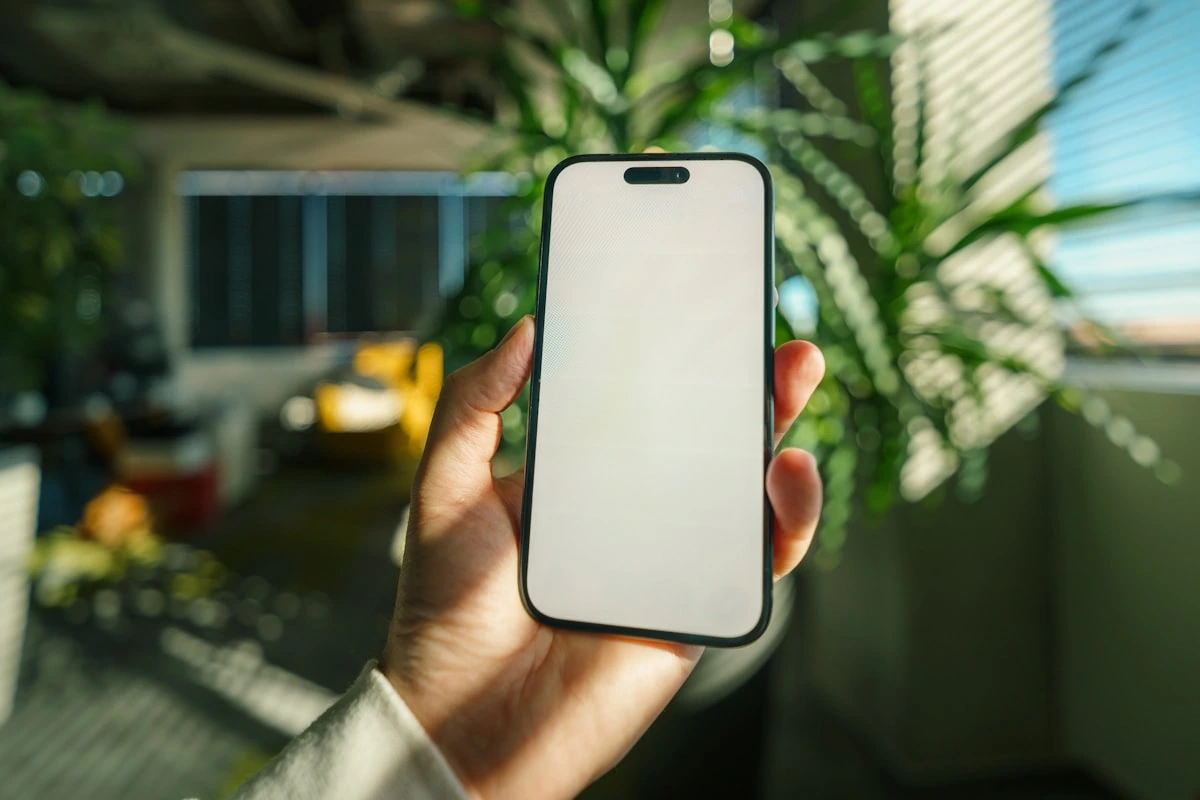 A hand holding a phone, where most people will see your mobile friendly website first. Photo by Jakub Zerdzicki on Unsplash.