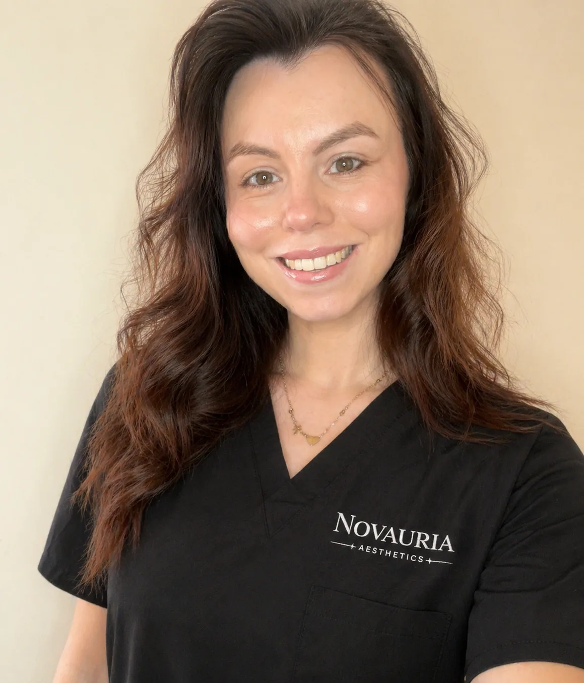 Liz, founder of Novauria Aesthetics, smiling in her Novauria uniform